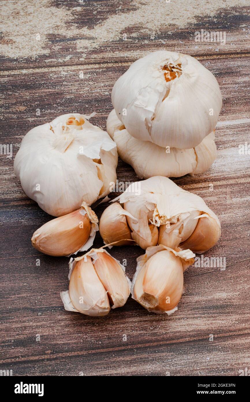 Garlic bulbs and cloves on rustic surface with copy space Stock Photo