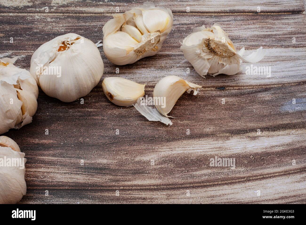 Garlic bulbs and cloves on rustic surface with copy space Stock Photo ...