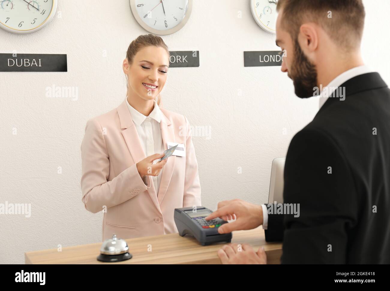 Businessman paying for hotel room at reception Stock Photo Alamy