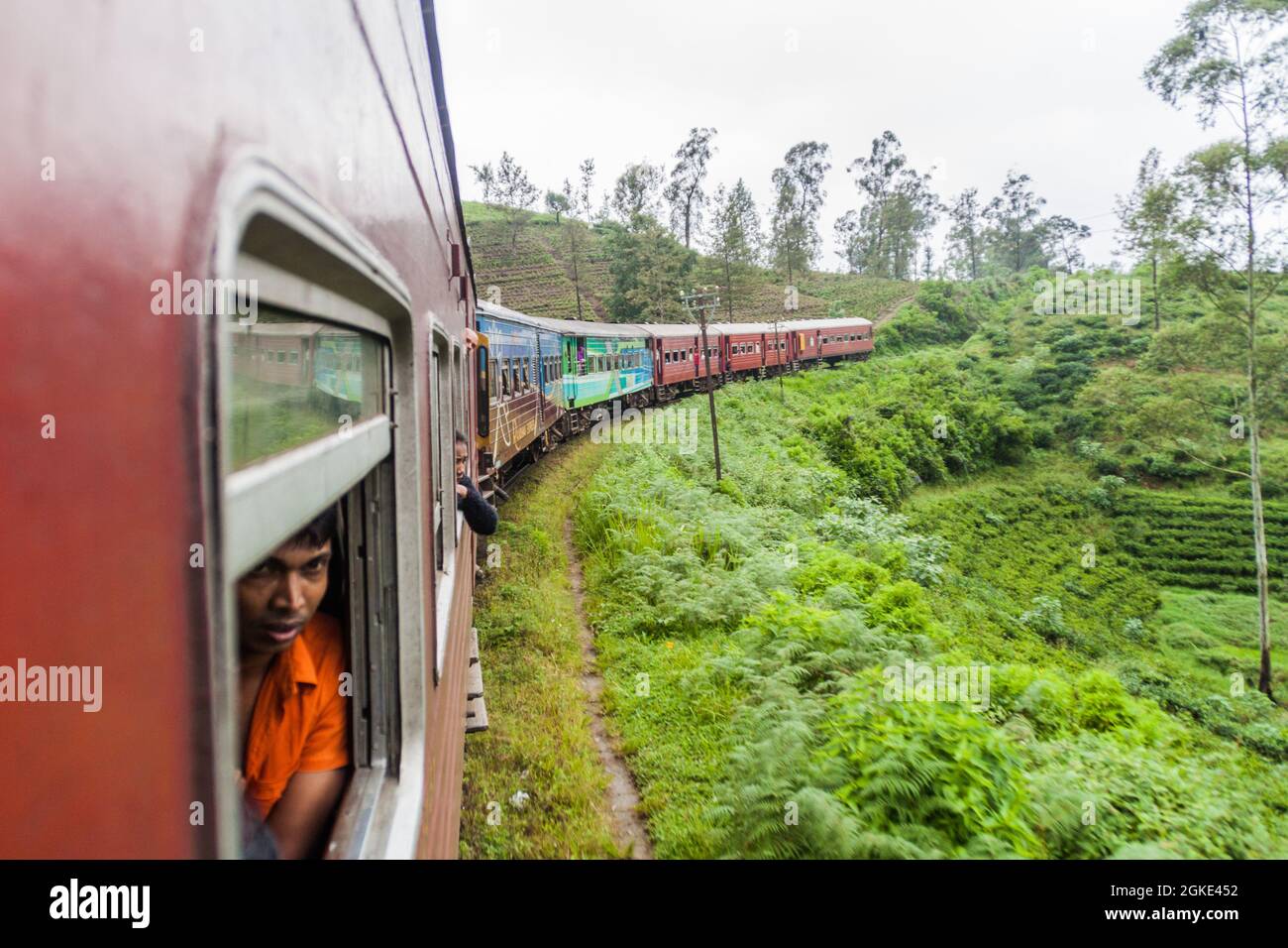 NANU OYA, SRI LANKA - JULY 16, 2016: Local train rides through a rural landscape near Nanu Oya village, Sri Lanka Stock Photo