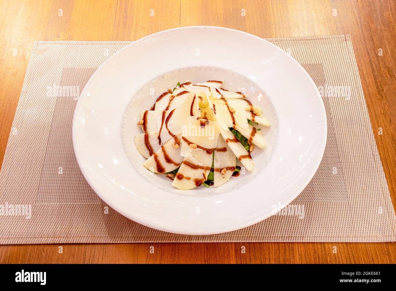 Pear flake salad with parmesan cheese flakes, sautéed pine nuts and