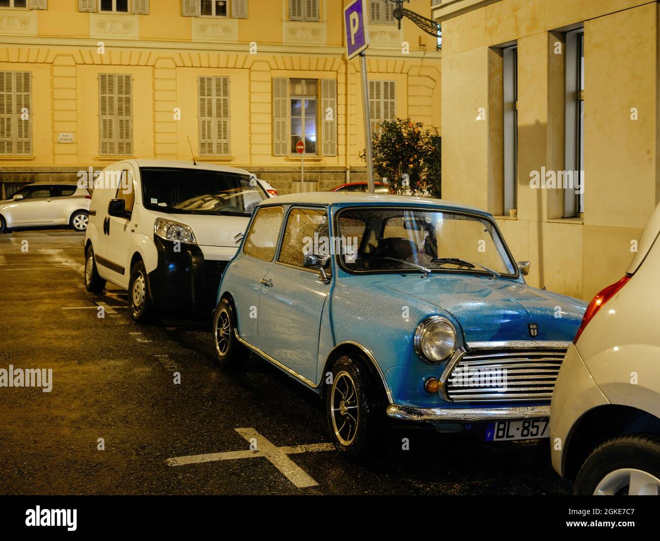 Old blue vintage Mini cooper car parked on the street at night Stock Photo