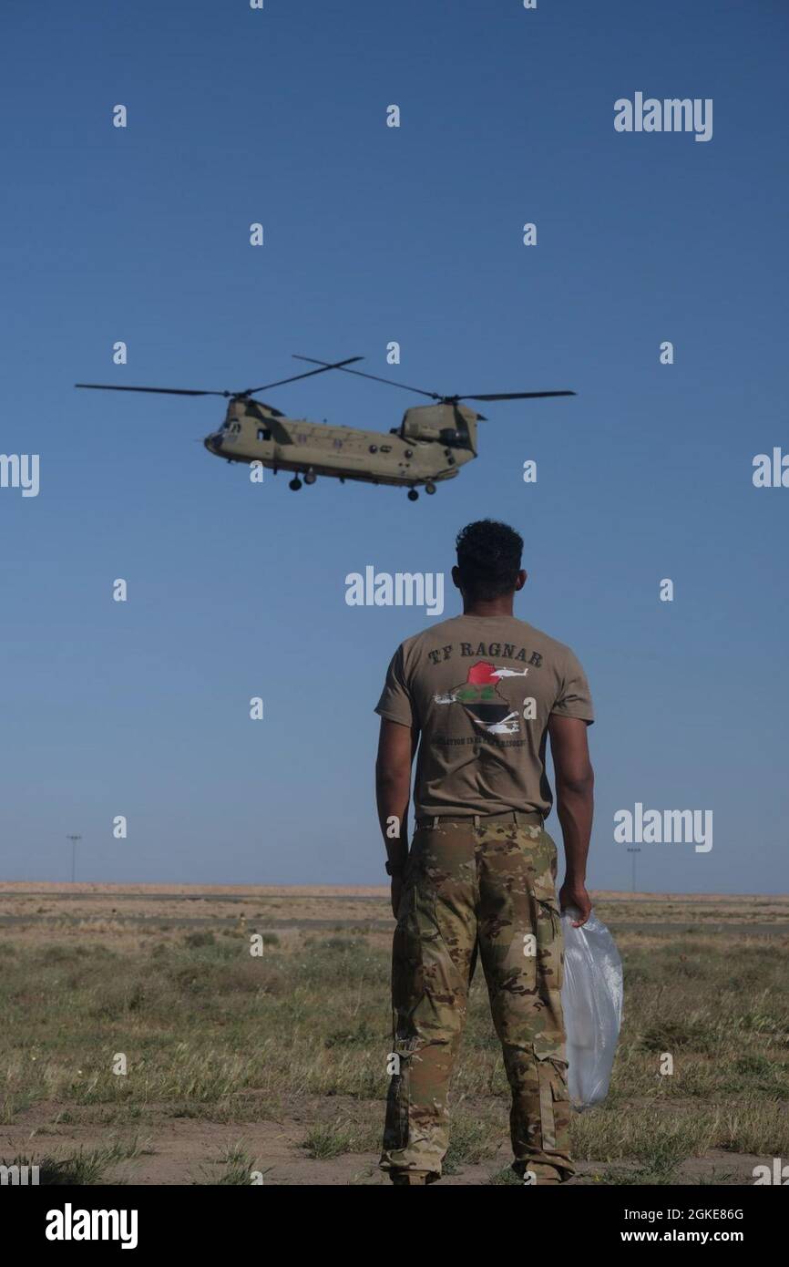 U.S. Soldiers with the 28th Expeditionary Combat Aviation Brigade clean up foreign object debris during a FOD walk at an airfield in the 28th ECAB's area of operations in the Middle East. FOD, including trash, rocks or vehicle parts, can cause serious damage to a helicopter so these FOD walks are important to keep our aircrews safe. Stock Photo