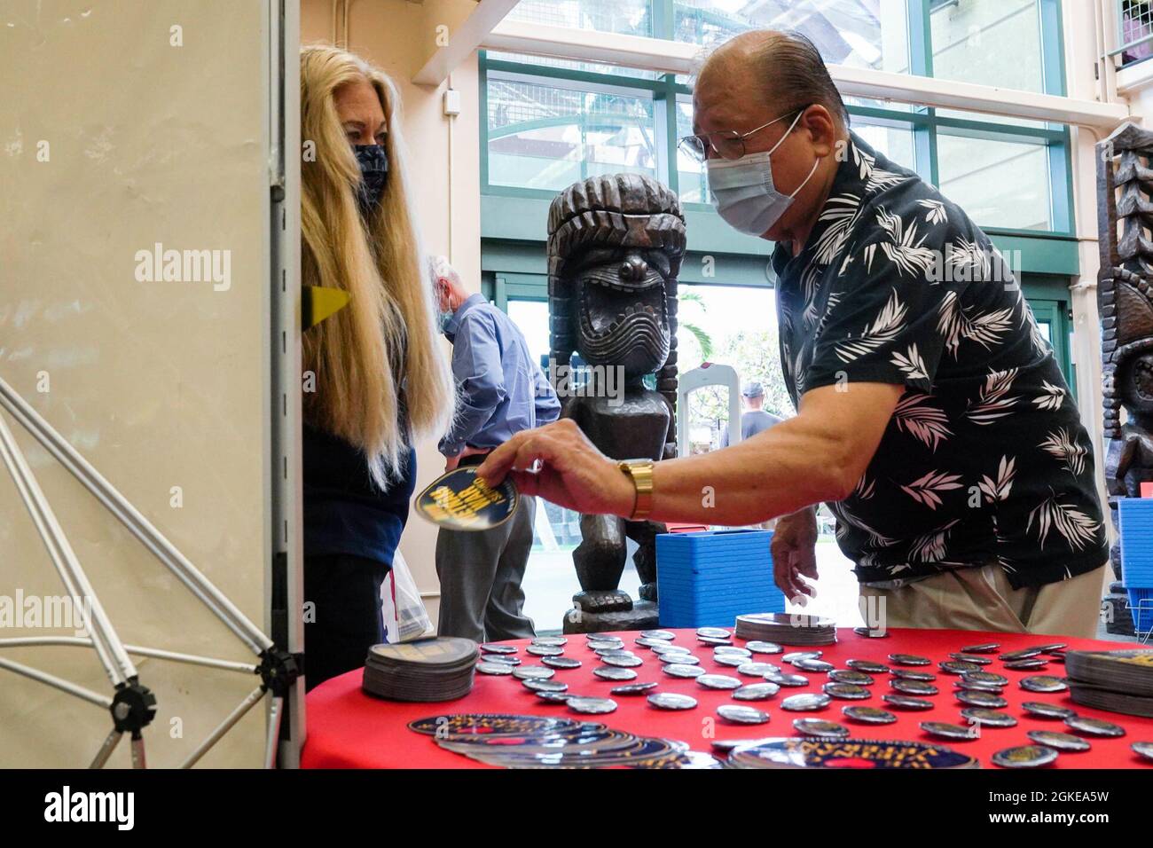 Yvonne Palmieri, Hickam Base Exchange store manager, assists Kenji