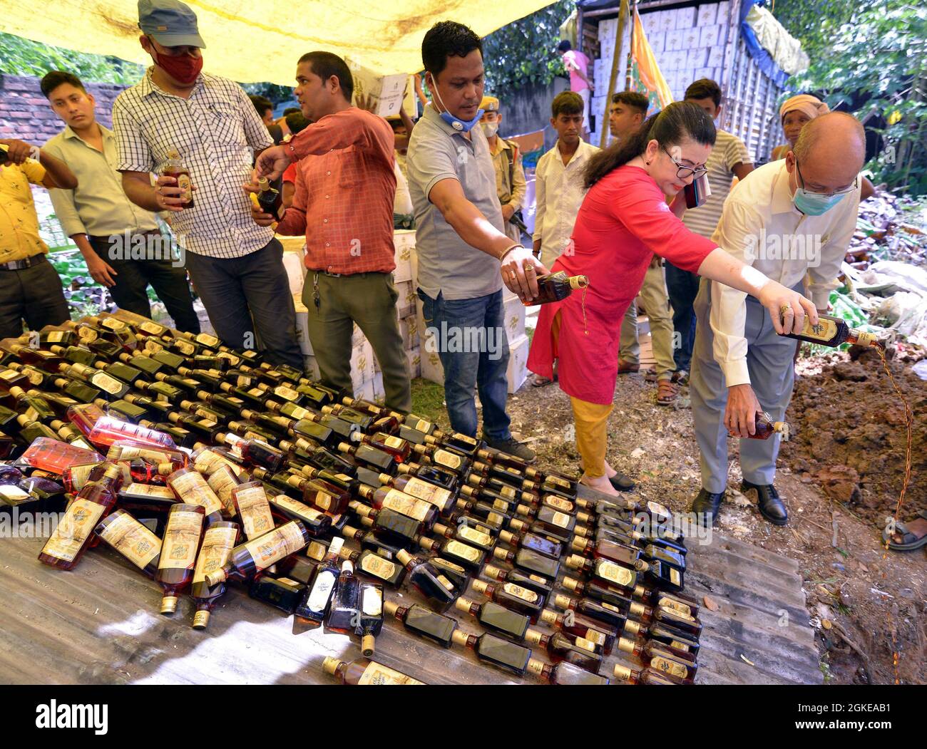 Guwahati, India. 14th Sep, 2021. Officials of the Bureau of Investigation Economic Offences (BIEO) pour away liquor which were seized by the sleuths of the department for illegal trading in Guwahati, India, on Sept. 14, 2021. More than 90 thousand bottles of liquor were destroyed during the raids. Credit: Str/Xinhua/Alamy Live News Stock Photo