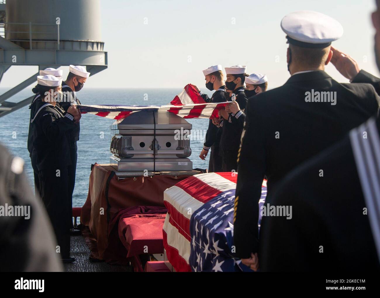 PACIFIC OCEAN (March 29, 2021) Sailors fold the national ensign during a burial at sea ceremony aboard Wasp-class amphibious assault ship USS Essex (LHD 2). Essex is underway conducting routine operations in U.S. Third Fleet. Stock Photo