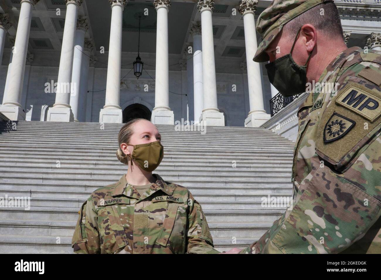 U.S. Army Maj. David Howe, right, of the Small Arms Readiness Training Section (SARTS), Garrison Training Center, Kentucky National Guard, presides over a promotion ceremony for Spc. Jordan Napper of Detachment 1, 2113th Transportation Company, Kentucky National Guard, near the U.S. Capitol in Washington, D.C., March 30, 2021. The National Guard has been requested to continue supporting federal law enforcement agencies with security, communications, medical evacuation, logistics, and safety support to state, district and federal agencies through mid-March. Stock Photo