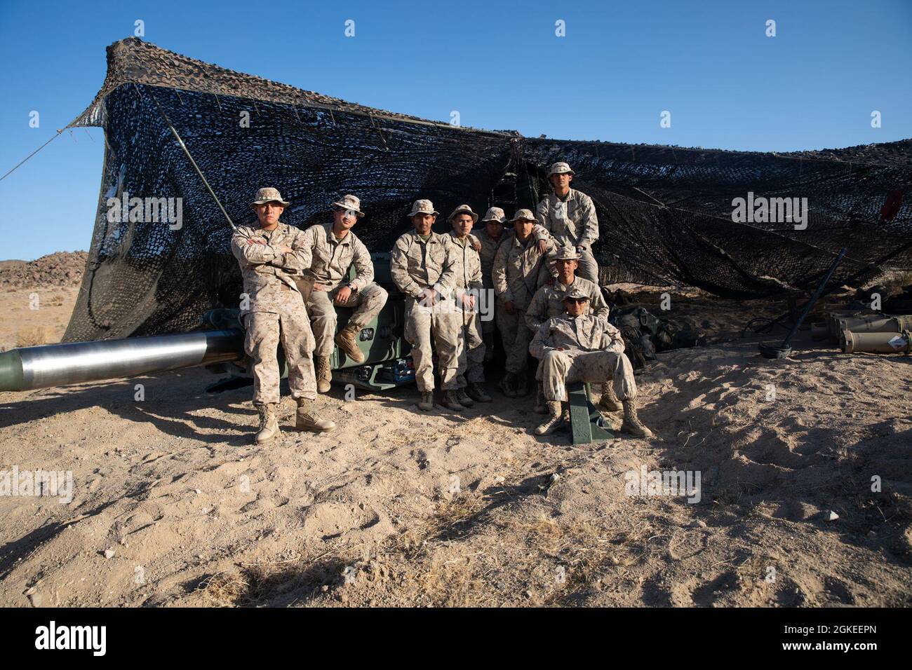 U.S. Marines with Battery A, 1st Battalion, 11th Marine Regiment, 1st Marine Division, stand by with an M777 towed 155 mm howitzer to commence a live-fire defense simulation at the Marine Corps Air Ground Combat Center in Twentynine Palms, California, March 30, 2021. This live-fire defense was set up with M777 towed 155 mm howitzers, .50-caliber machine guns, M240B machine guns as well as M4 carbines and M16A1 rifles, to repel notional enemy attacks from the artillery position. Stock Photo
