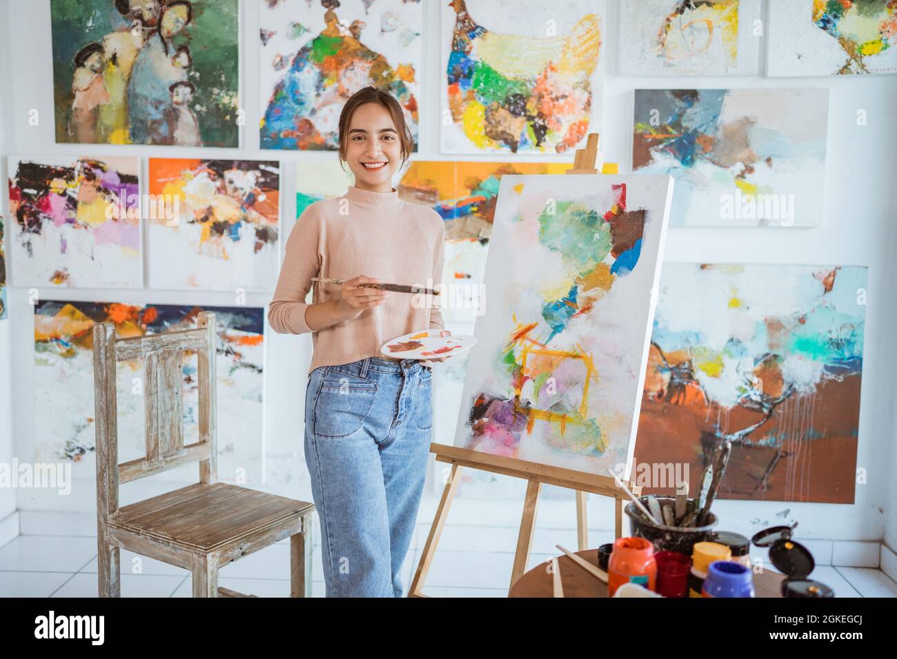 asian female artist painting on canvas doing some art projects on her ...