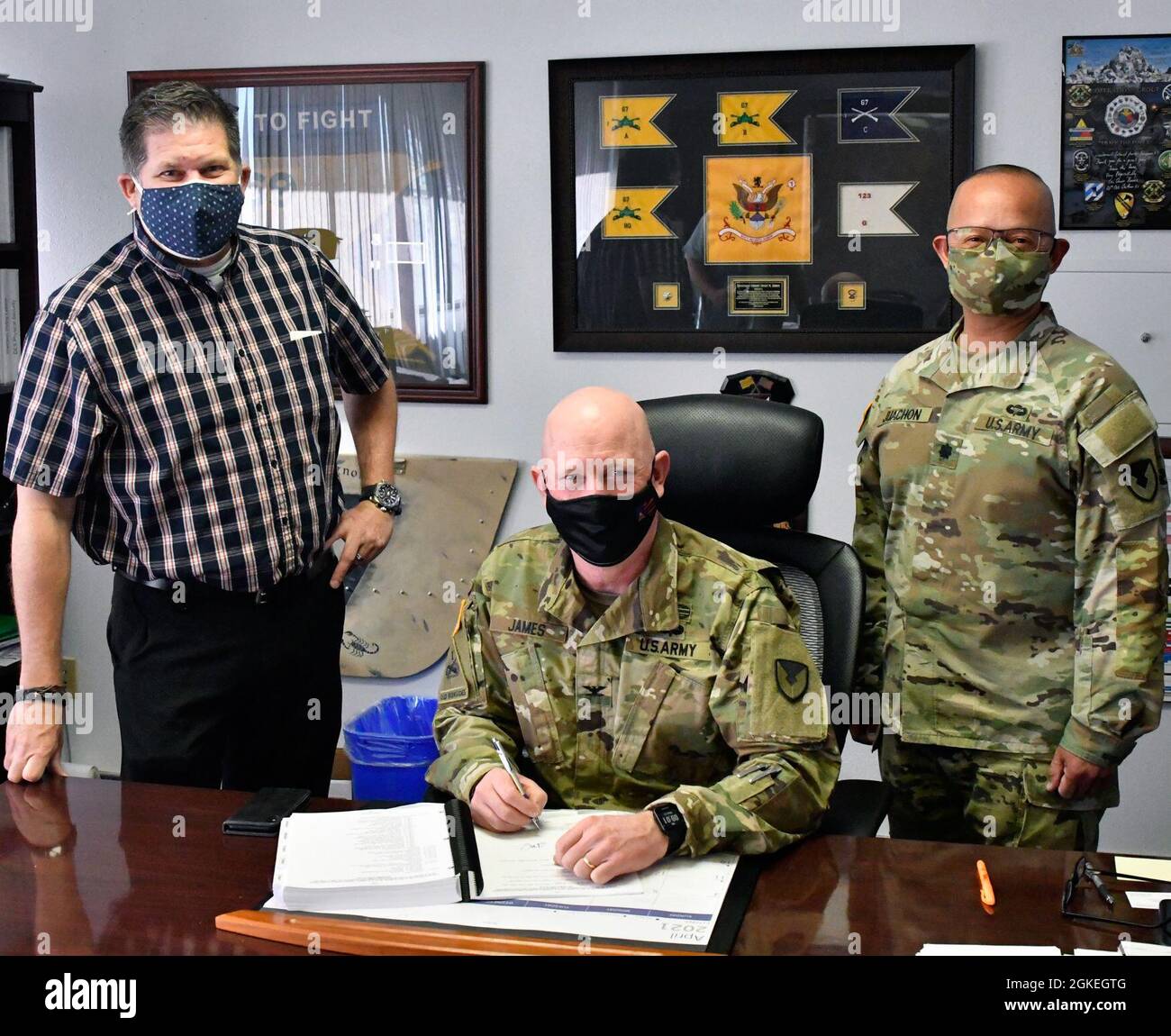 U.S. Army Col. Stu James, commander, U.S. Army Garrison Fort Bliss, center, signs the Fort Bliss Installation Mobilization Support Plan, March 31, 2021, Fort Bliss, Texas. James is accompanied by Mr. Jaymes Picott, mobilization chief, left; and Lt. Col. John Juachon, mobilization planner, right; both assigned to the Mobilization Division, Directorate of Plans, Training, Mobilization & Security (DPTMS). Stock Photo