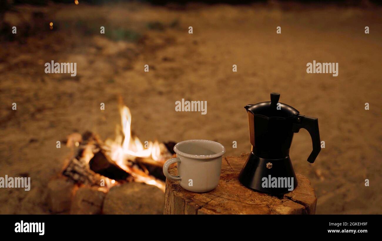 Background photo with camping coffee maker next to a campfire Stock Photo