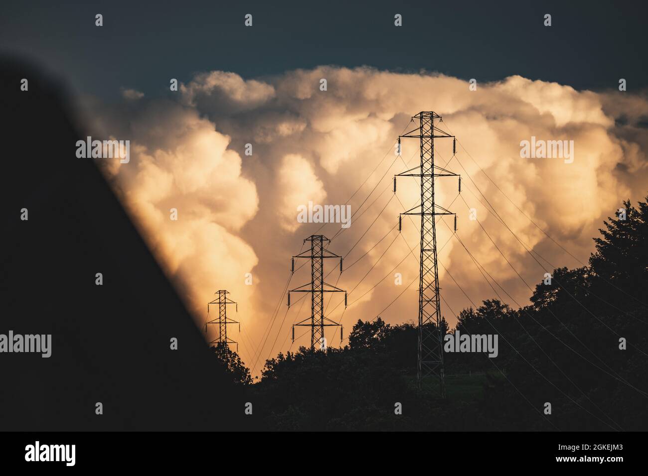 Transmission towers under the sky with big fluffy clouds Stock Photo ...