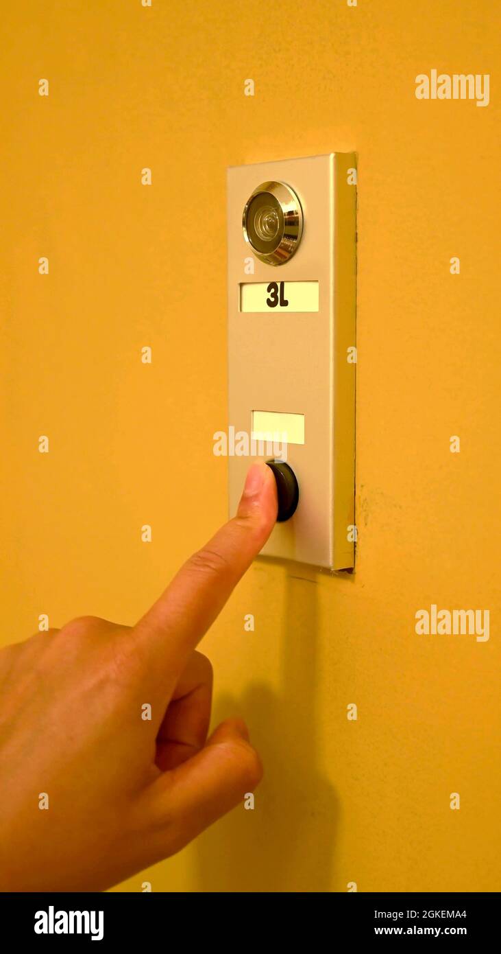 Hand of a woman who is ringing a doorbell Stock Photo