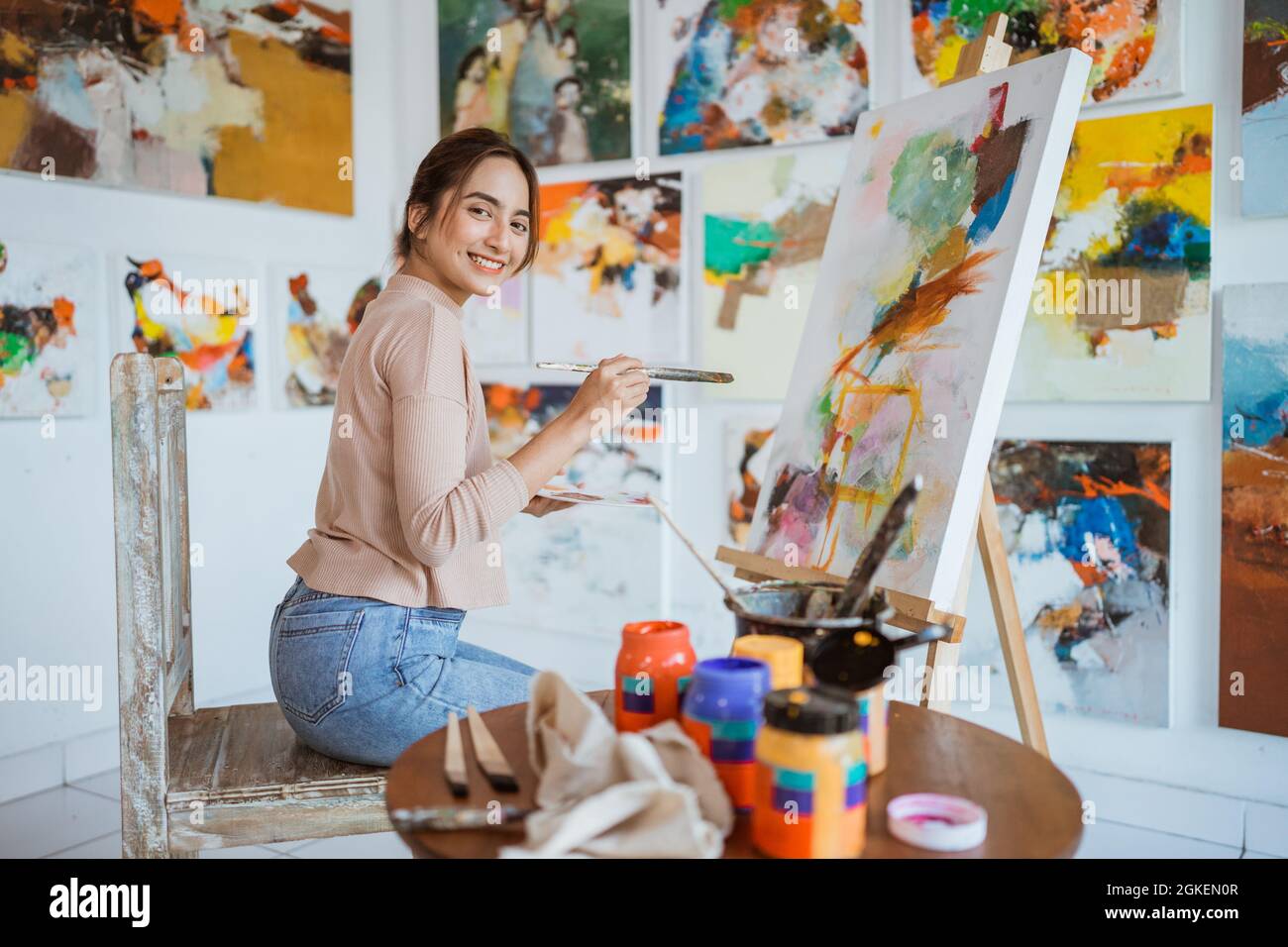 asian female artist painting on canvas doing some art projects on her ...