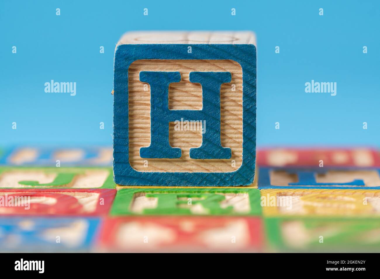 Closeup shot of a colorful, educational alphabet, ABC wooden blocks the letter H in the middle Stock Photo