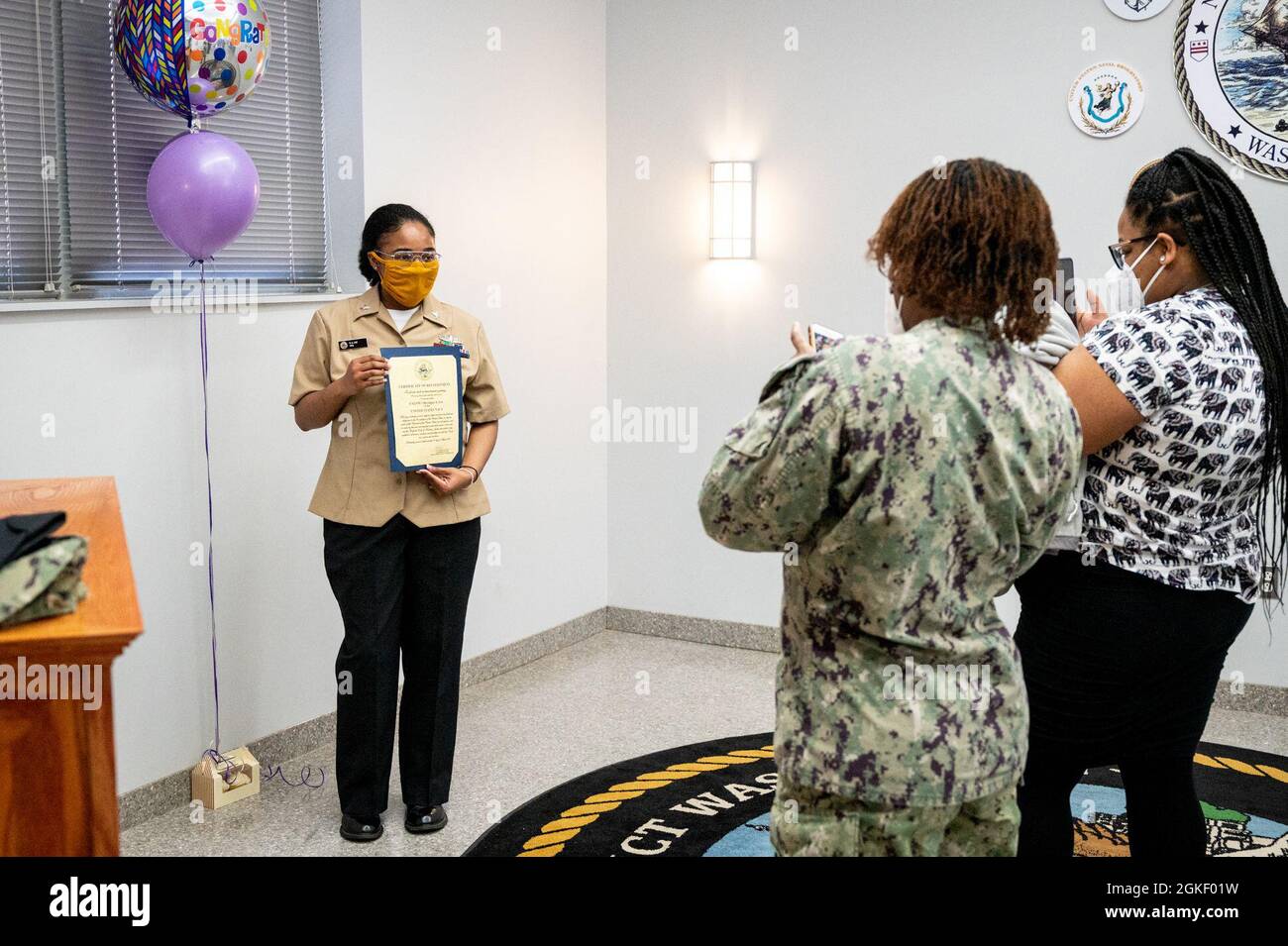WASHINGTON, DC (April 2, 2021) – Culinary Specialist 2nd Class Sheniqua Lee, left, poses for a photo following her reenlistment ceremony onboard Washington Navy Yard. Stock Photo