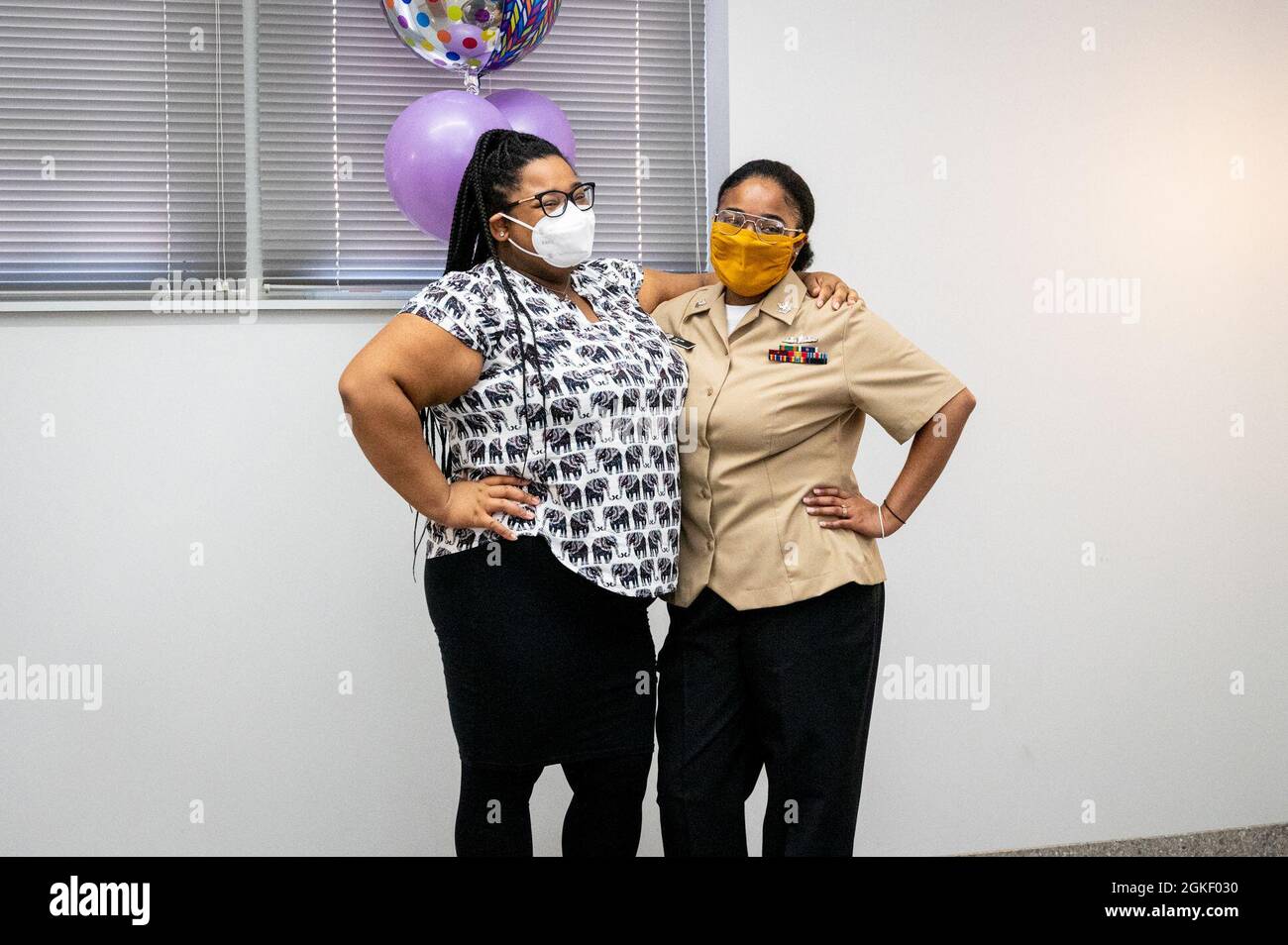 WASHINGTON, DC (April 2, 2021) – Culinary Specialist 2nd Class Sheniqua Lee, right, poses with ceremony guests following her reenlistment onboard Washington Navy Yard. Stock Photo