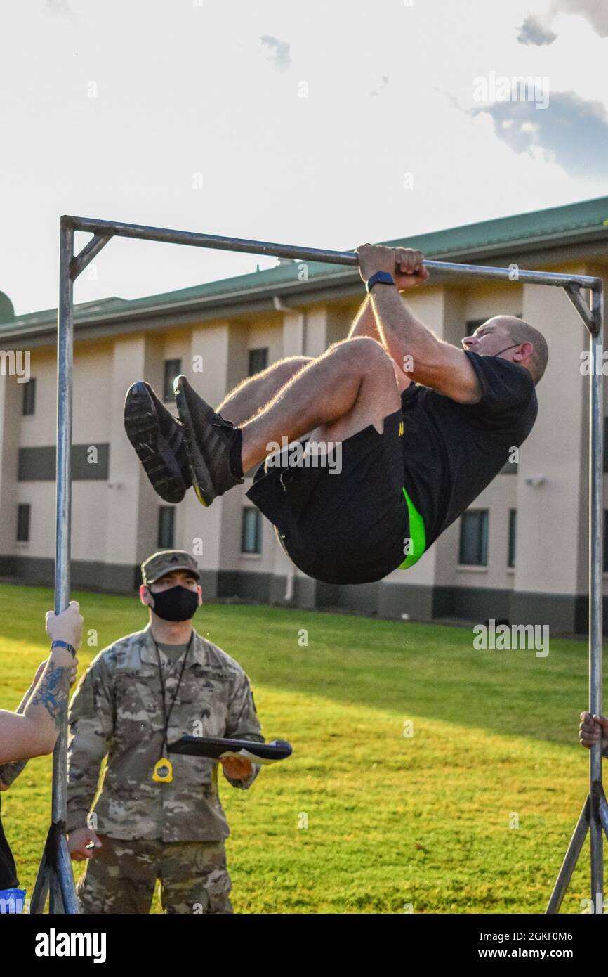 Hawaii Army National Guard Soldier, Staff Sgt. Hondo Ho, a Human Resources Specialist with Headquarters and Headquarters Company, 103rd Troop Command performs the leg tuck (LTK) event during the Army Combat Fitness Test, Waimanalo, Hawaii, April 2, 2021. The LTK measures upper and lower body explosive power, flexibility, and dynamic balance assisting with tasks like a buddy drag, throwing a hand grenade and employing progressive levels of force in man-to-man contact. The six-event readiness assessment, ACFT, is intended to replace the current three-event Army Physical Fitness Test, which has b Stock Photo