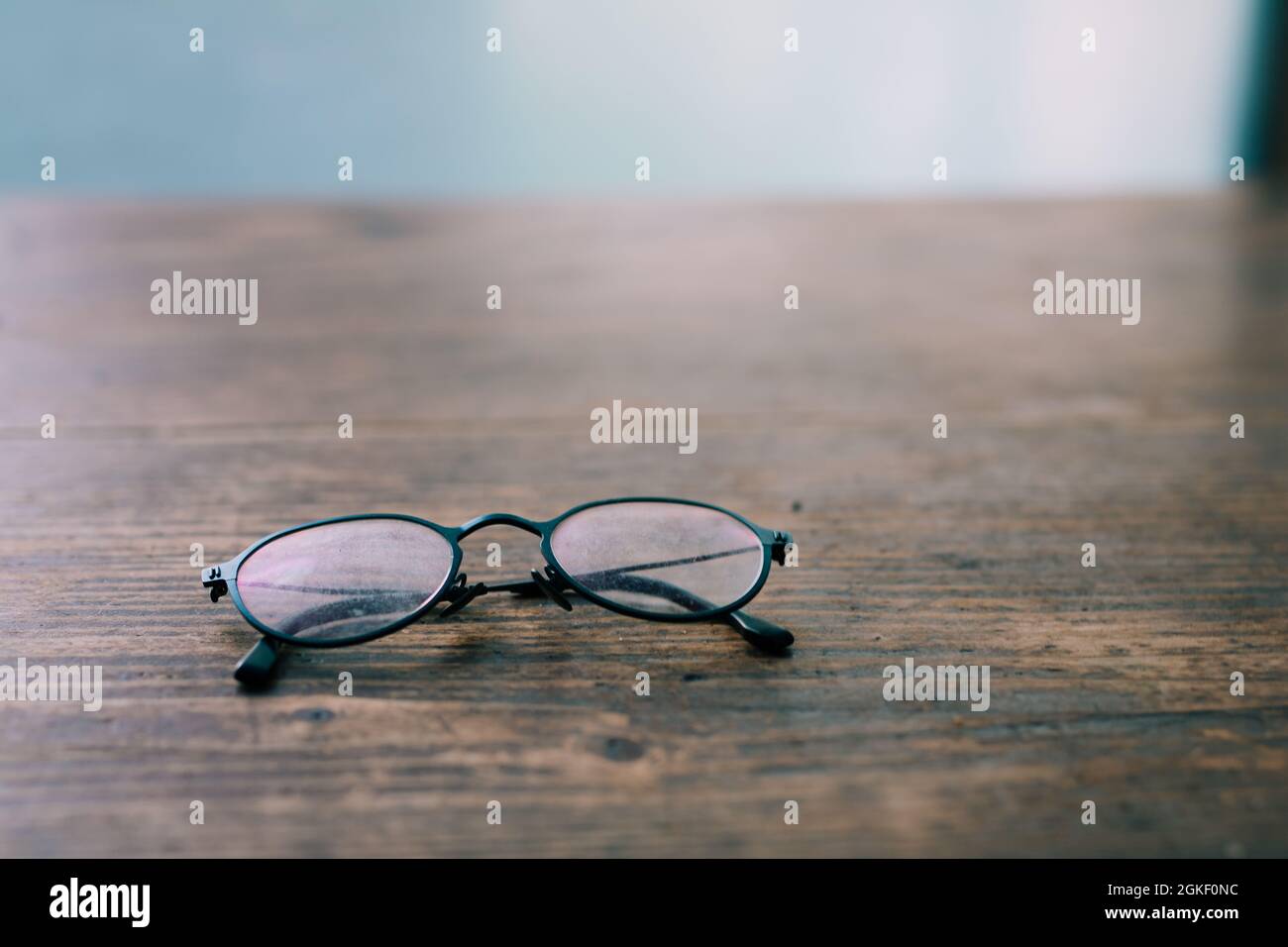 Bad eye sight or myopic - Reading glasses for elderly on wooden table close-up soft focus Stock Photo