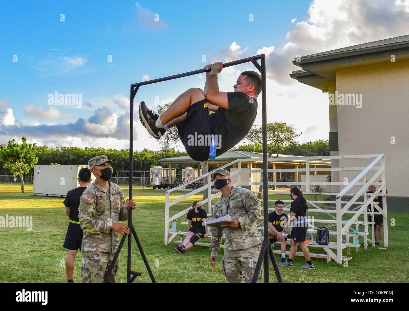 Hawaii Army National Guard Soldier, Capt. Adam Herrmann, a Logistics Officer with Headquarters and Headquarters Company, 103rd Troop Command performs the leg tuck (LTK) event during the Army Combat Fitness Test, Waimanalo, Hawaii, April 2, 2021. The LTK measures upper and lower body explosive power, flexibility, and dynamic balance assisting with tasks like a buddy drag, throwing a hand grenade and employing progressive levels of force in man-to-man contact. The six-event readiness assessment, ACFT, is intended to replace the current three-event Army Physical Fitness Test, which has been aroun Stock Photo