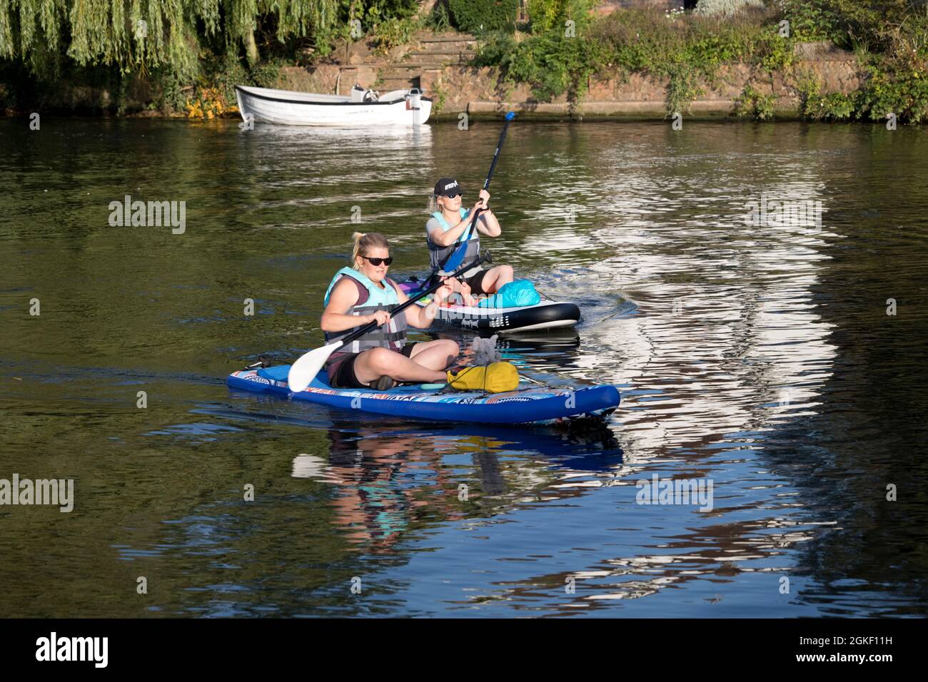 Two women sitting on two paddleboards paddleboarding River Avon