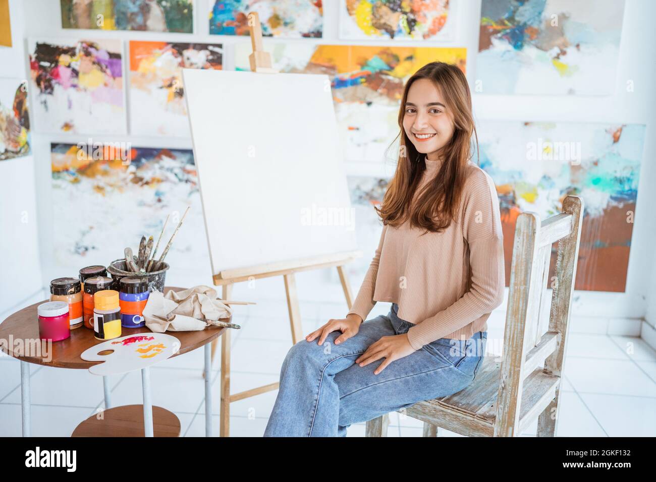 asian female artist painting on canvas doing some art projects on her ...