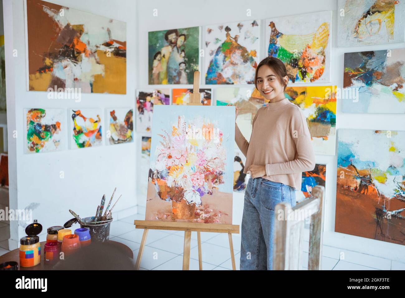 asian female artist painting on canvas doing some art projects on her ...
