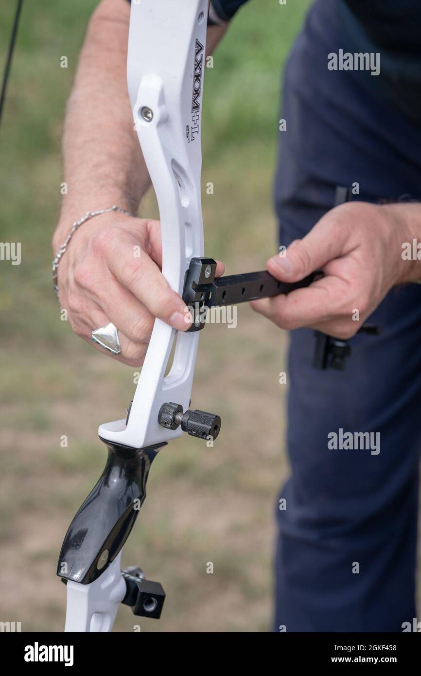 Steve Arnold, volunteer archery coach, adjusts a bow sight as part of
