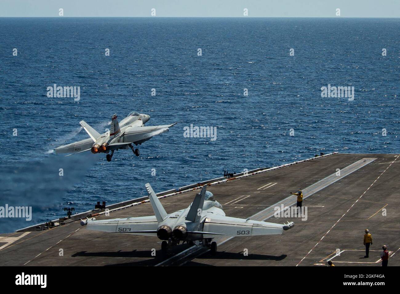 SOUTH CHINA SEA (April 6, 2021) – An F/A-18E Super Hornet, assigned to the “Golden Warriors” of Strike Fighter Squadron (VFA) 87, launches from the flight deck of the aircraft carrier USS Theodore Roosevelt (CVN 71) April 6, 2021. The Theodore Roosevelt Carrier Strike Group is on a scheduled deployment to the U.S. 7th Fleet area of operations. As the U.S. Navy’s largest forward-deployed fleet, 7th Fleet routinely operates and interacts with 35 maritime nations while conducting missions to preserve and protect a free and open Indo-Pacific Region. Stock Photo