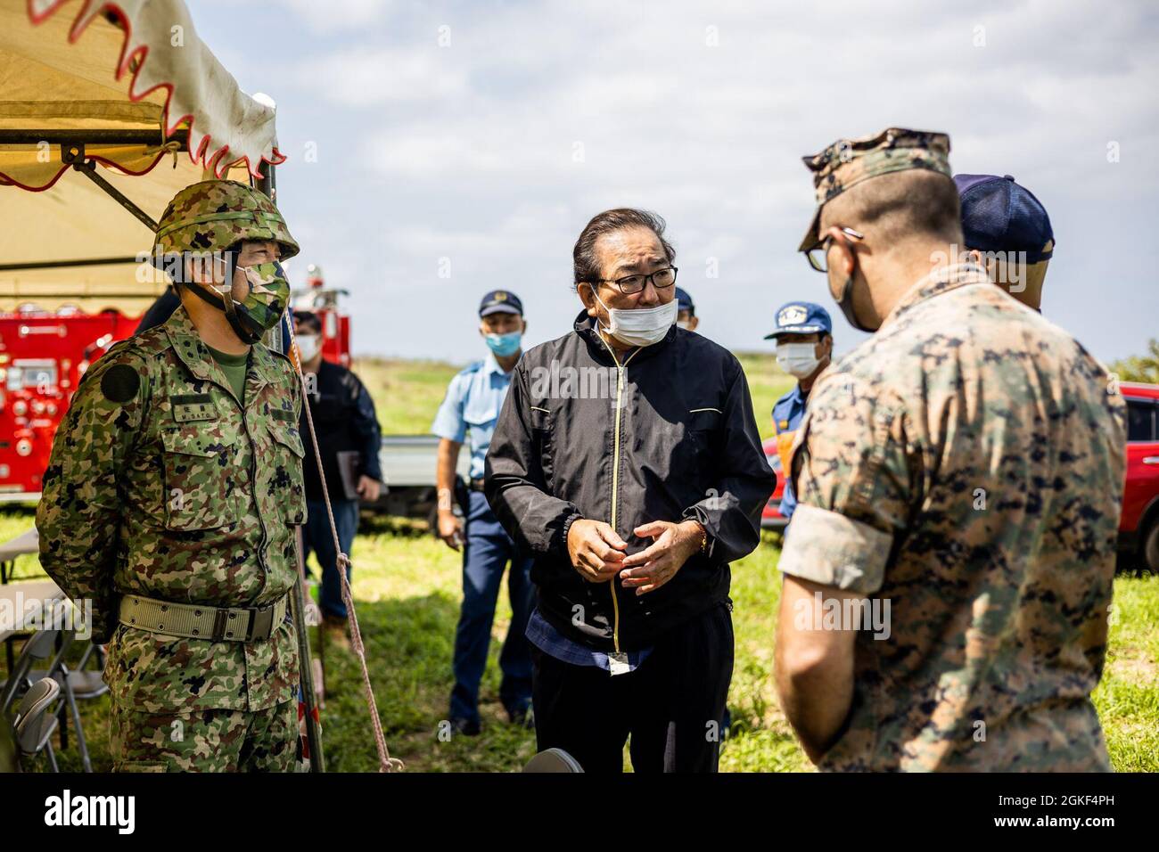 Japan Ground Self-Defense Force (JGSDF) Maj. Gen. Sato Makoto, left, the 15th Brigade commanding general, Hideyuki Shimabukuro, middle, the Ie Village office mayor and Marine Corps Installations Pacific representatives, right, discuss about the unexploded ordnance Stock Photo