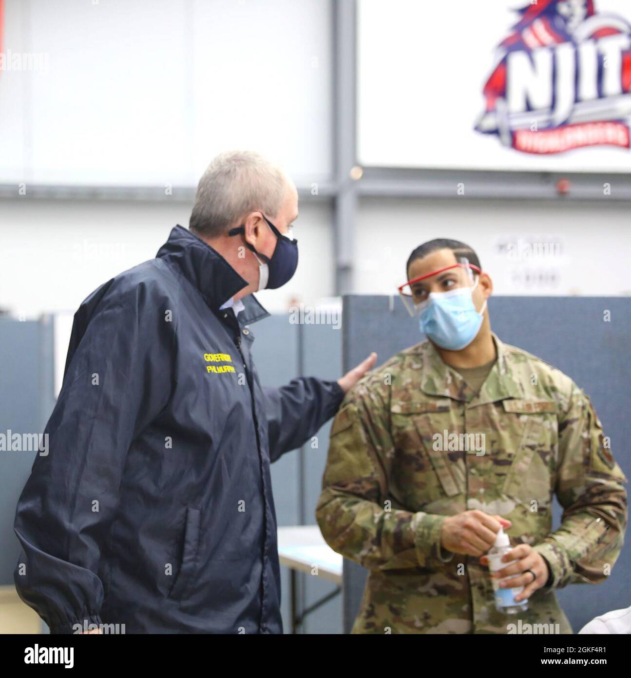 New Jersey Gov. Phil Murphy converses with U.S. Air Force Master Sgt. Johel De Leon, a Perth Amboy, New Jersey, native and medical technician assigned to the 59th Medical Operations Squadron, prior to administering a COVID-19 vaccination during the Governor’s visit to the New Jersey Institute of Technology Community Vaccination Center in Newark, April 6, 2021, for an NBC Evening News interview with Lester Holt. U.S. Northern Command, through U.S. Army North, remains committed to providing continued, flexible DoD support to the Federal Emergency Management Agency as part of the whole-of-governm Stock Photo