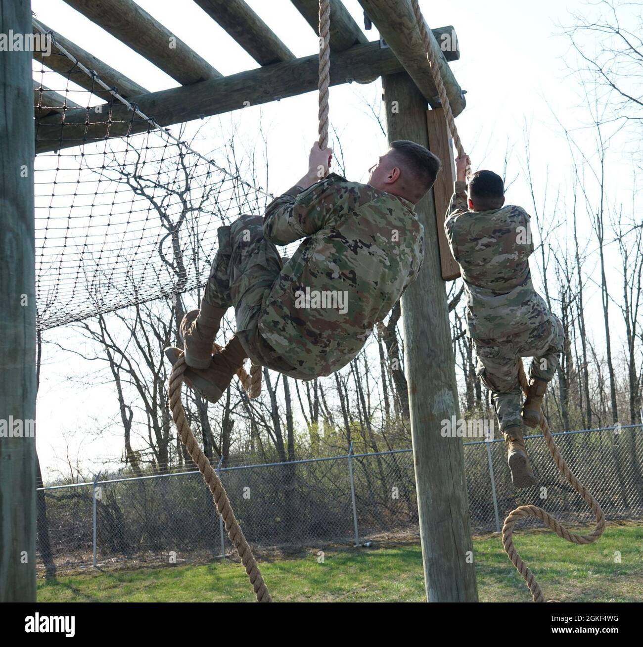 Two Soldiers fight to climb their ropes during the first obstacle