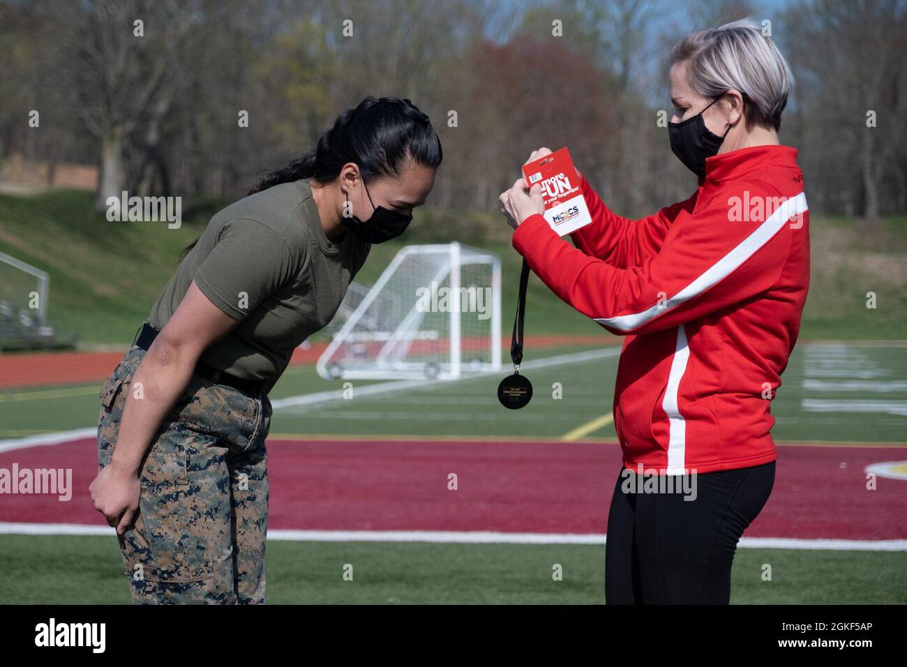 U.S. Marine Corps Sgt. Davonn Vong with Headquarters and Service Battalion receives her first-place medal at Butler Stadium, Marine Corps Base Quantico, Va., Apr. 6, 2021. Vong receives her medal for finishing at the top of her age and gender group. Stock Photo