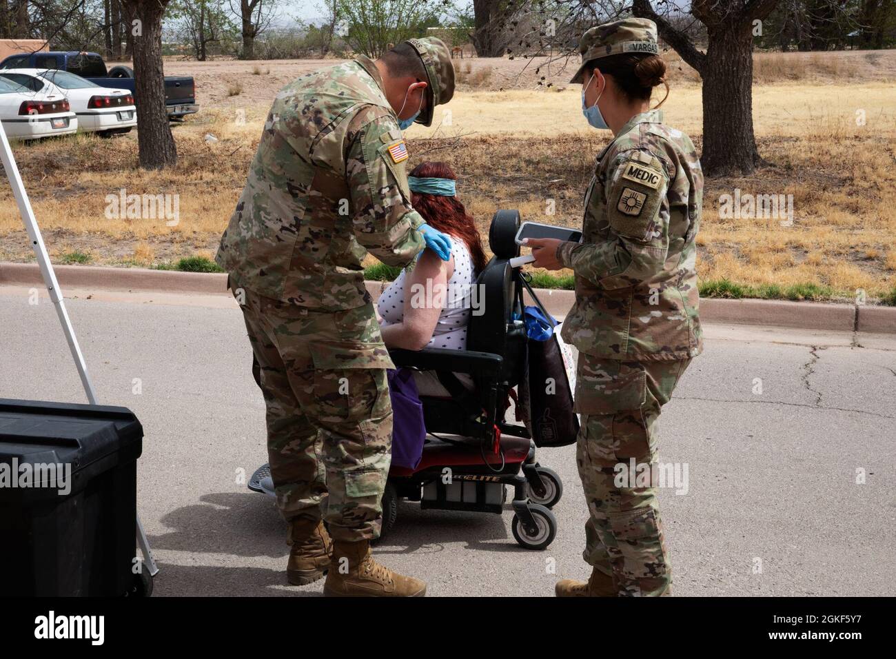 Spc. Jose Villegas, a medic with the 1209th MCAS, and Spc. Angelica Vargas, a medic with HHC 1-200th Inf. Batt., NMNG, vaccinate a citizen who is unable to drive during a drive-thru vaccination event held in Mesilla Valley, N.M., April 6, 2020. Villegas and Vargas are assigned to National Guard Equity Team - South, which is tasked with vaccinating rural populations of New Mexico. Stock Photo