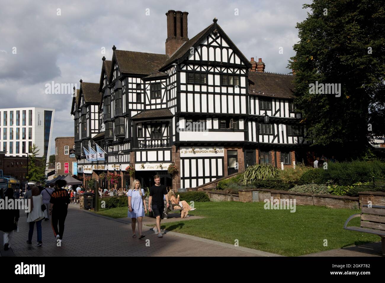 People strolling by Flying Standard Wetherspoon black and white half timbered public house in central  Coventry Warwickshire UK Stock Photo