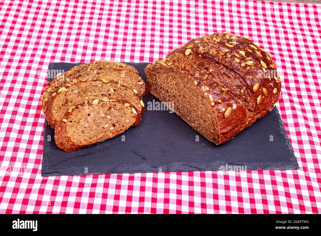 Freshly baked Pumpernickel boule rye bread on a slate serving platter Stock Photo