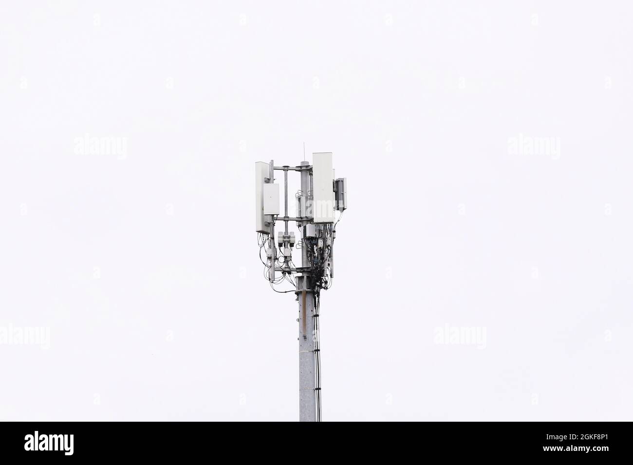 A mobile telephone communications mast as seen with a clear white sky over Belfast, Northern Ireland. Stock Photo