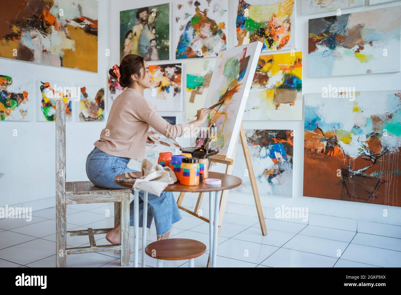 asian female artist painting on canvas doing some art projects on her ...