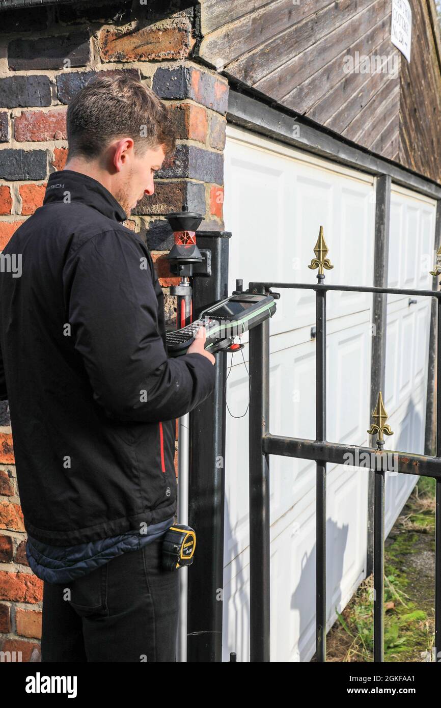 A surveyor undertaking a topographical survey using a Leica pinpoint R500 total station, or total station theodolite, England, UK Stock Photo