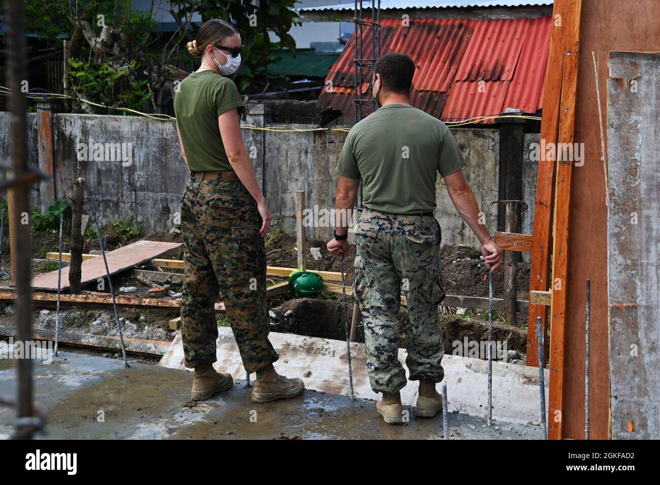 U.S. Marine Capt. Melanie Sluzewicz (left), 9th Engineer Support Battalion  company commander, and Master Sgt. Jeremy Roberts (right), 9th ESB company operations chief, discuss the next steps in the construction of the two-classroom building during Balikatan 21 in Barangay Ilosong, Plaridel, Ph., April 7, 2021. Balikatan, now in its 36th year, is an example of the long-standing friendship between the Philippines and United States in action. Stock Photo