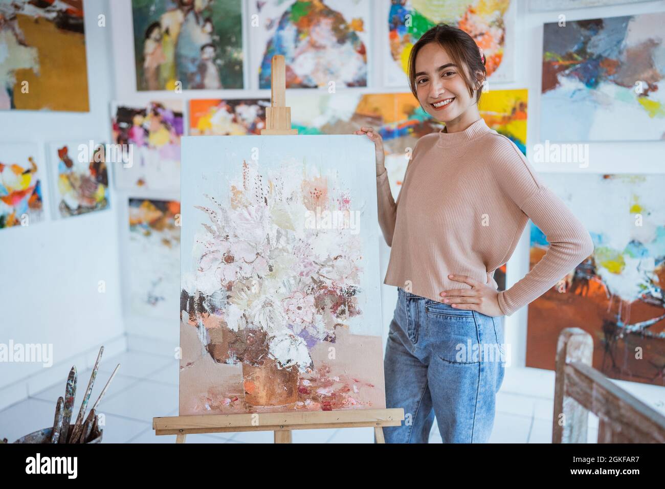 asian female artist painting on canvas doing some art projects on her ...