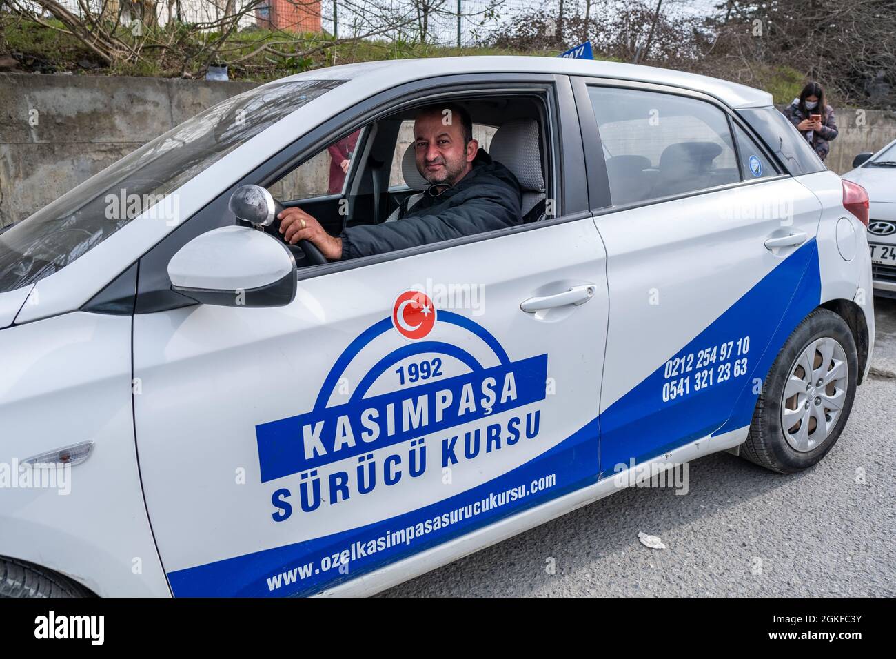 Kemerburgaz, Istanbul, Turkey - 03.19.2021: middle aged male instructor of driving test car sitting on car seat in Turkey before test day. Translation Stock Photo