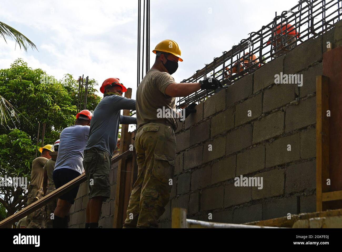 U.S. Army Soldiers and Philippine Navy Seabees place a rebar cage for