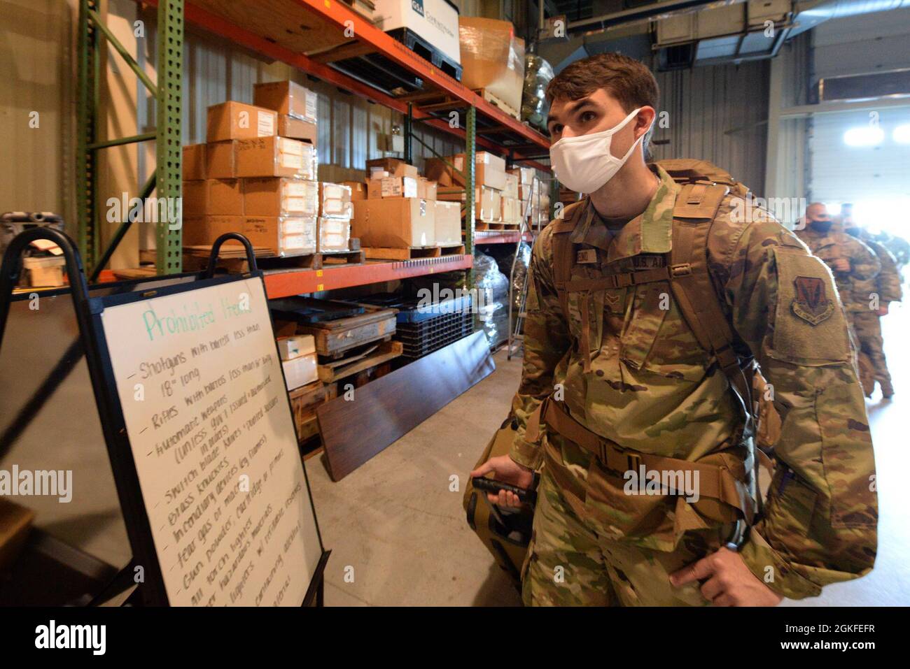 U.S. Air Force Airman 1st Class Brian Angelino, a sheet metal mechanic with the 177th Fighter Wing of the New Jersey Air National Guard, reviews a prohibited items list as he processes through the 177th Logistics Readiness Squadron warehouse area, prior to boarding a rotator aircraft at Atlantic City Air National Guard Base, N.J., Apr. 6, 2021. 177FW Airmen boarded the Boeing 747 rotator aircraft for an Air Expeditionary Force deployment to the Middle East, in support of U.S. Central Command. Stock Photo