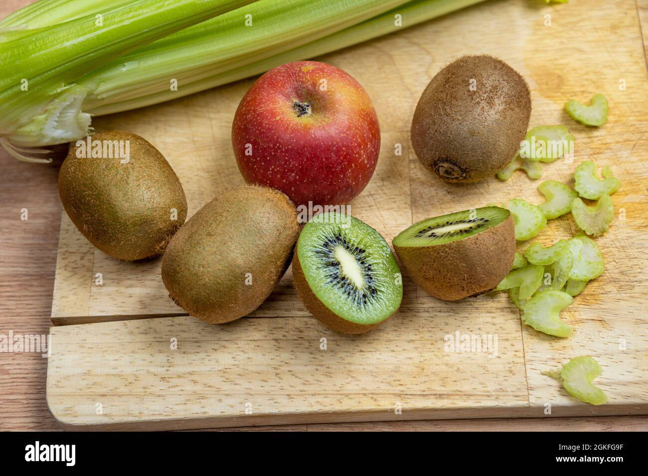 Ripe kiwis, apples and celery cut to prepare a healthy detox juice Stock Photo