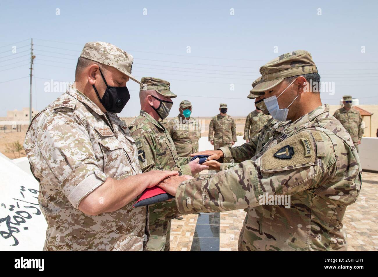 The Jordanian Armed Forces, Southern Command, 3rd Border Guard Group Commander, Col. Ra'ad Al Aamayra, and Task Force Spartan Division Tactical- Jordan Officer in Charge, Col. Christopher Fletcher, exchange flags in a symbolic gesture of friendship and partnership following the successful completion of the Desert Warrior 21 live-fire exercise, April 8, 2021. The exercise was viewed by JAF General Officers and senior leaders from U.S. Army Central and TF Spartan. Moments of expressed gratitude help to solidify the enduring relationship between the two forces. Stock Photo