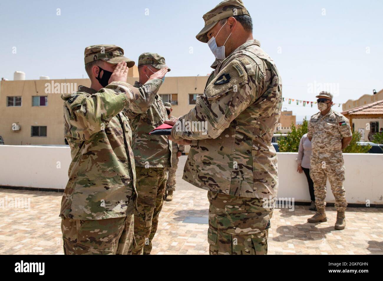 The Jordanian Armed Forces, Southern Command, 3rd Border Guard Group Commander, Col. Ra'ad Al Aamayra, and Task Force Spartan Division Tactical- Jordan Officer in Charge, Col. Christopher Fletcher, exchange flags in a symbolic gesture of friendship and partnership following the successful completion of the Desert Warrior 21 live-fire exercise, April 8, 2021. The exercise was viewed by JAF General Officers and senior leaders from U.S. Army Central and TF Spartan. Moments of expressed gratitude help to solidify the enduring relationship between the two forces. Stock Photo
