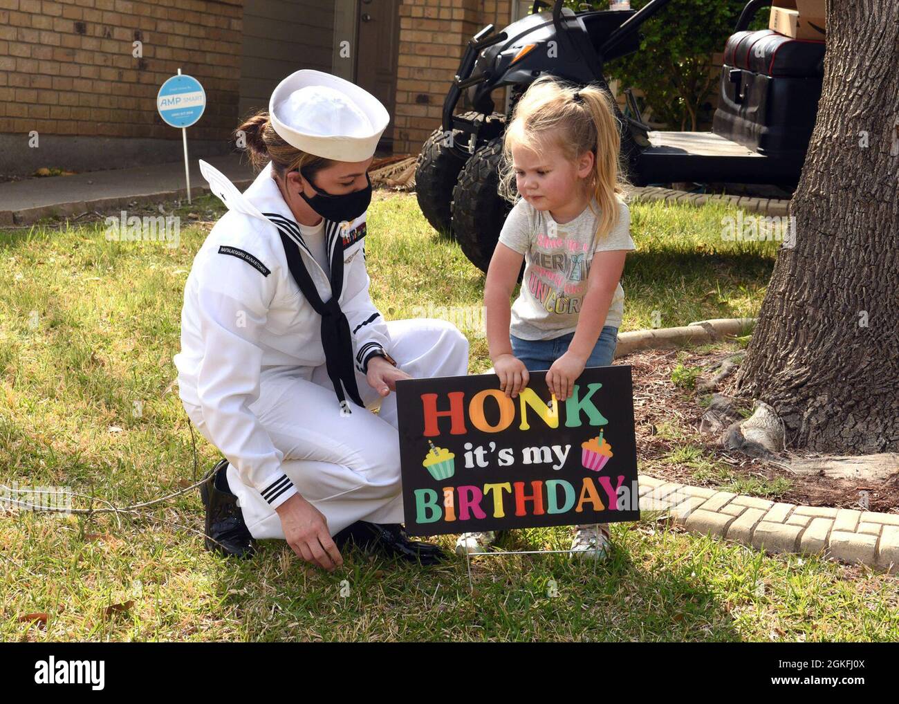TEMPLE, Texas – (April 9, 2021) Naval Aircrewman (Helicopter) 2nd Class Katherine Knox, of Copperas Cove, Texas, the leading petty officer assigned to Navy Recruiting Station (NRS) Temple, Talent Acquisition Onboarding Center (TAOC) Capital City, joined by her daughter, Blake, prepares to honor retired Chief Petty Officer Joseph New on his 90th birthday held at his home.  New, a native of Troy, S.C., was raised in Washington, D.C., and joined the Navy in 1952 serving for 20 years as a ship’s serviceman. He served on numerous ships to include the aircraft carrier, USS Independence (CV-62) which Stock Photo