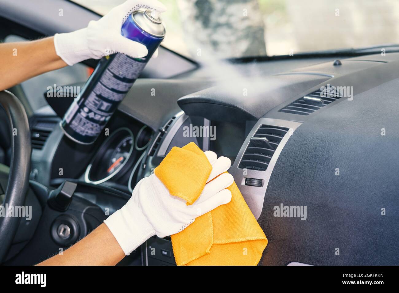 Car interior care services. A plastic cleaner and a rag in the cleaner's  hand. Cleaning of the car interior. Cleaning company Stock Photo - Alamy