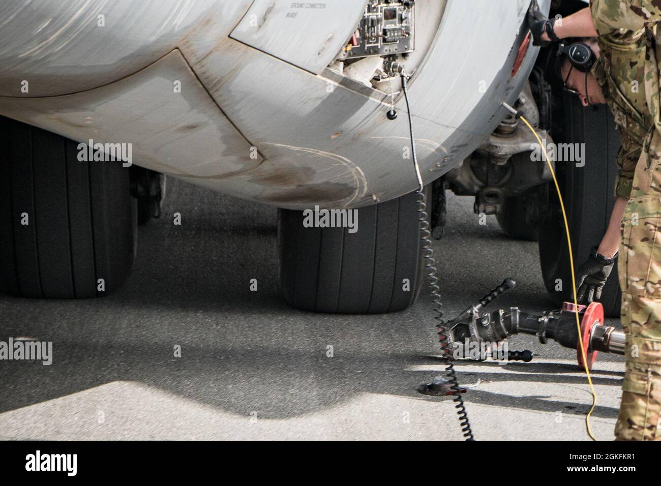 U.S. Air Force Staff Sgt. Roberto Barraza, loadmaster for the 816th Expeditionary Airlift Squadron, sets down a fuel hose after conducting C-17 Globemaster III hot refueling operations during a training and certification mission at Al Udeid Air Base, Qatar, April 9, 2021. The 816th EAS and 379th Expeditionary Logistics Readiness Squadron Airmen performed multiple iterations of a process where the Aerial Bulk Fuel Delivery System was drained into an R-11 fuel truck, then the engines were left running for hot refueling from the truck to the aircraft, as well as a defueling process from the plane Stock Photo